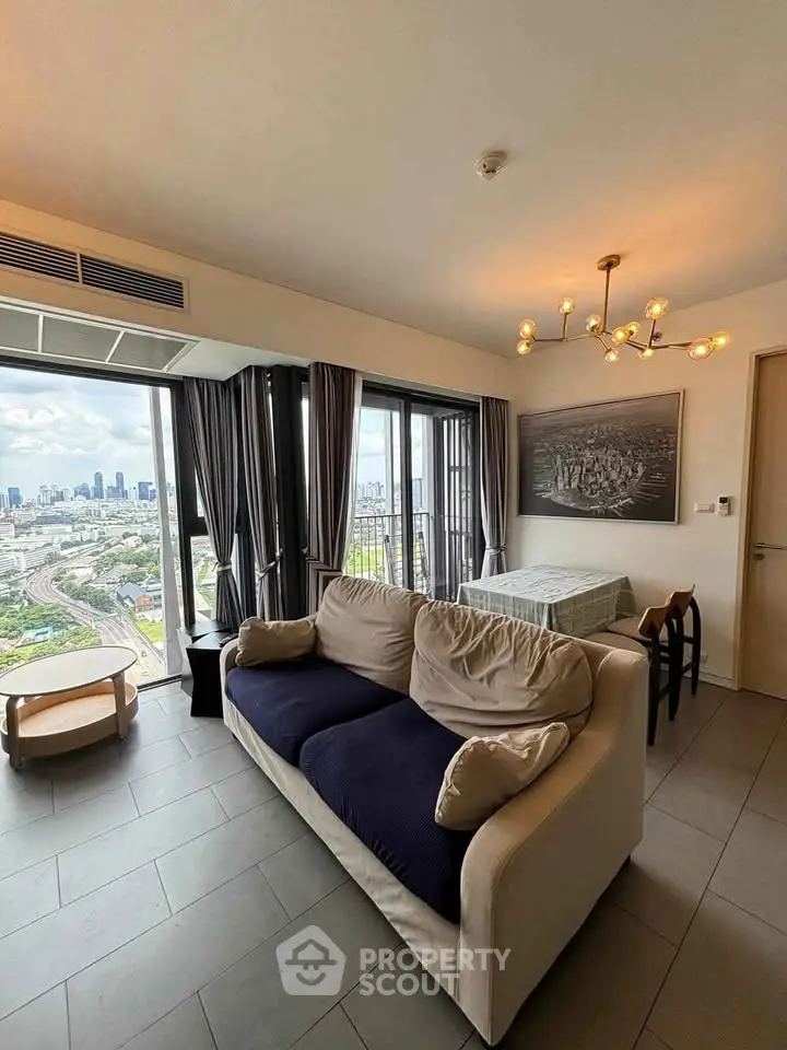 Modern living room with city view, stylish lighting, and cozy seating area.