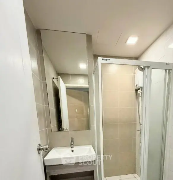 Modern bathroom with sleek shower and stylish sink in contemporary apartment.