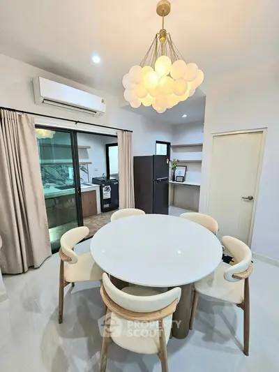 Modern dining area with elegant chandelier and open kitchen layout