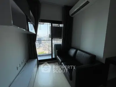 Modern living room with balcony view and sleek black sofa in urban apartment