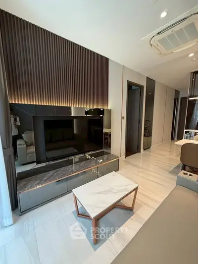 Modern living room with sleek design, featuring a marble coffee table and stylish TV unit.