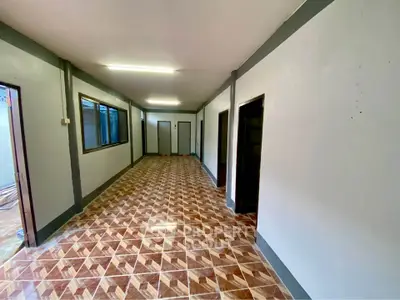 Spacious corridor with modern tile flooring and multiple doorways, ideal for versatile use.