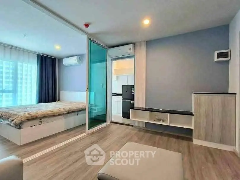 Modern apartment interior with bedroom and living area, featuring sleek design and natural light.
