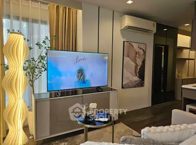 Modern living room with stylish decor and large TV, featuring elegant lighting and cozy seating.