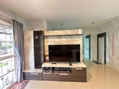 Modern living room with sleek TV unit and marble accents, offering a stylish and comfortable ambiance.