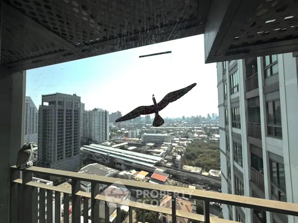 Stunning high-rise balcony view overlooking cityscape with modern buildings and clear skies.