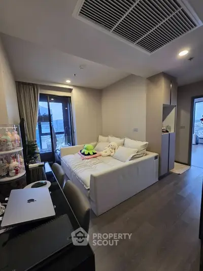 Cozy bedroom with modern decor and balcony access, perfect for relaxation and comfort.