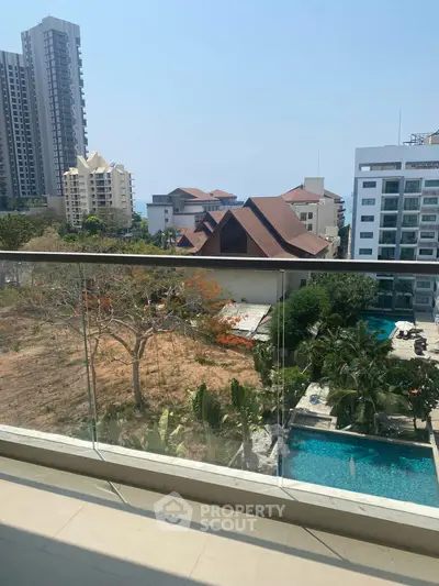Stunning balcony view overlooking cityscape and pool, perfect for urban living.