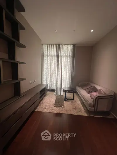 Cozy living room with elegant furniture and natural light through sheer curtains.