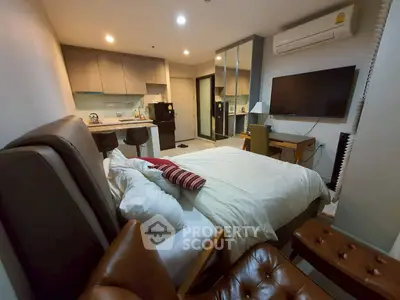 Modern studio apartment with cozy bed and open kitchen layout