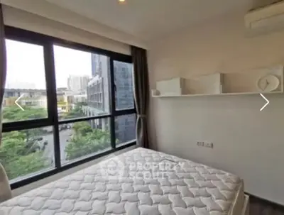 Bright bedroom with large windows offering city view, modern decor, and air conditioning.