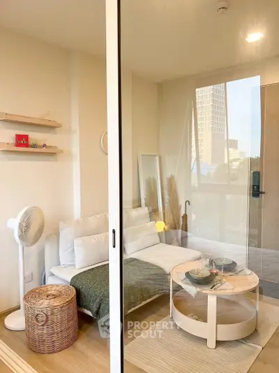 Chic modern living room with cozy sofa, stylish decor, and large window view in urban apartment.