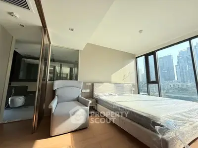 Modern bedroom with city view, featuring large windows and sleek design.