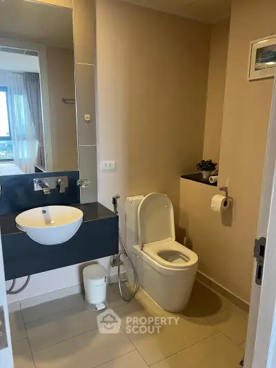 Modern bathroom with sleek fixtures and a view into the bedroom, showcasing contemporary design.