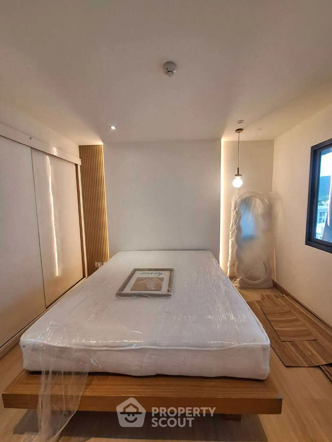 Modern minimalist bedroom with natural light and sleek design elements.