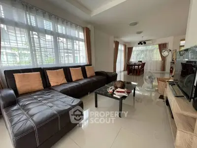 Spacious living room with modern leather sofa and large windows for natural light.