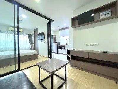 Modern open-plan living room with glass partition and sleek furnishings