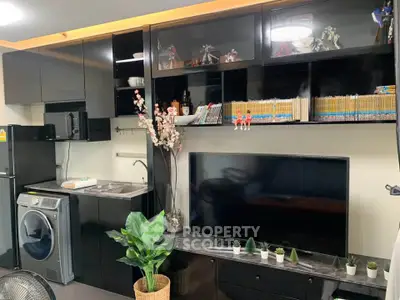 Modern living room with sleek black cabinetry, entertainment center, and compact kitchen appliances.