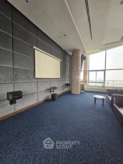 Spacious modern living room with projector screen and large windows