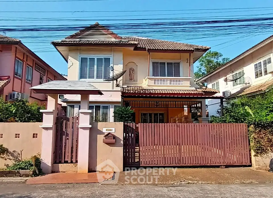 Charming two-story house with gated entrance and tiled roof in a suburban neighborhood.