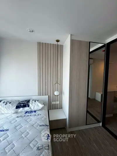 Modern bedroom with stylish decor and mirrored wardrobe in a contemporary apartment.