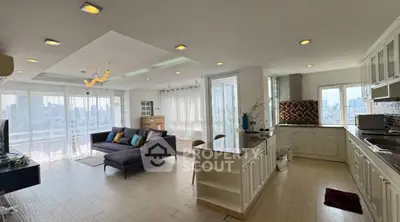 Spacious open-plan living room and kitchen with panoramic city views, modern decor, and abundant natural light.