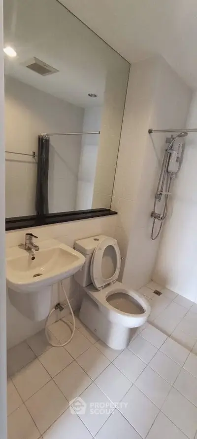 Modern bathroom with sleek fixtures and large mirror in a contemporary apartment.