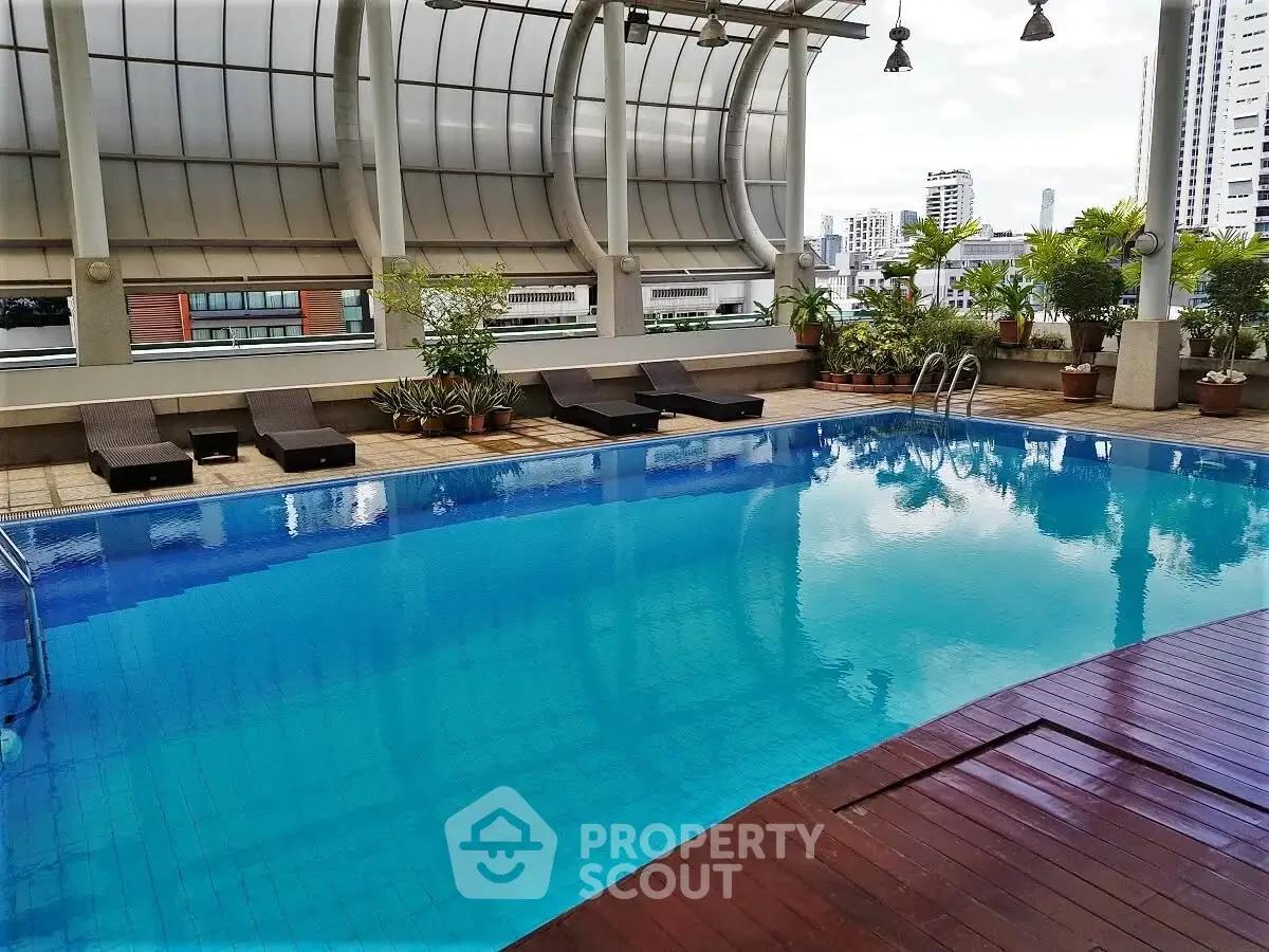 Luxurious rooftop pool with city views and stylish lounge chairs in a modern urban setting.
