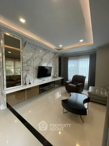 Luxurious modern living room with marble accent wall and sleek furniture.