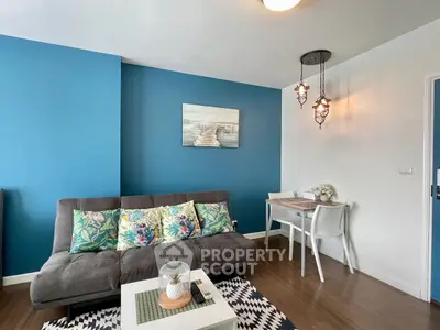 Charming living room with vibrant blue accent wall and cozy seating area.