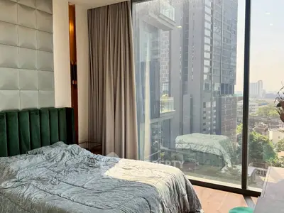 Luxurious bedroom with floor-to-ceiling windows offering stunning city views