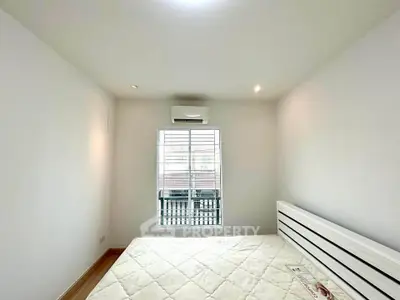Bright minimalist bedroom with large window and air conditioning