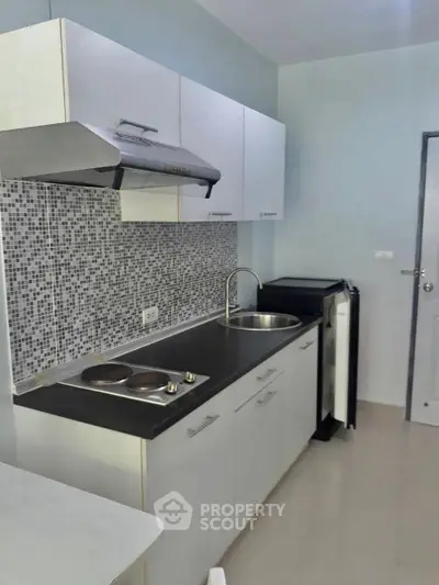 Modern compact kitchen with sleek cabinets and mosaic backsplash