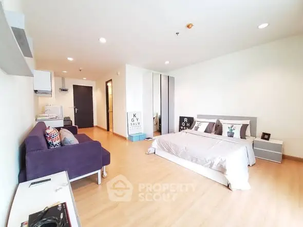 Spacious modern bedroom with cozy seating and stylish decor