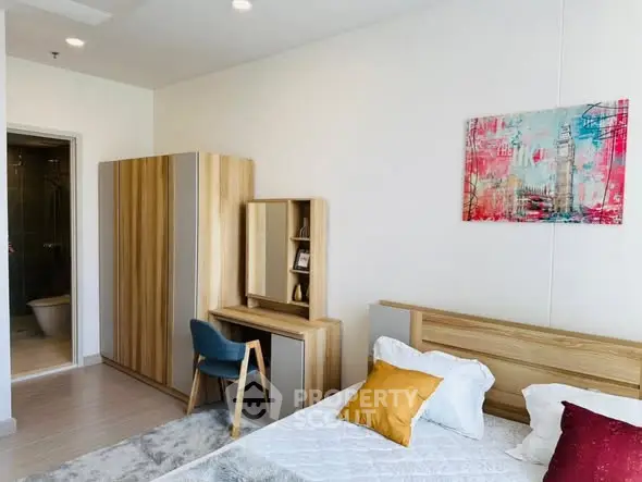 Modern bedroom with stylish furniture and colorful artwork, featuring a cozy bed and a sleek wardrobe.