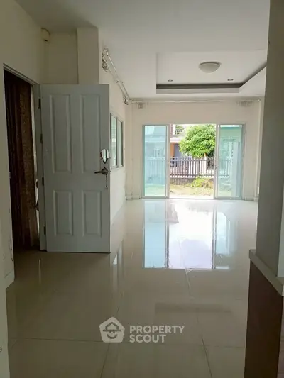 Spacious living room with large windows and garden view, perfect for natural light lovers.