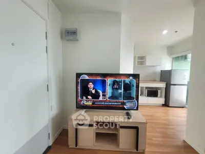 Modern living room with TV and open kitchen layout in a stylish apartment.