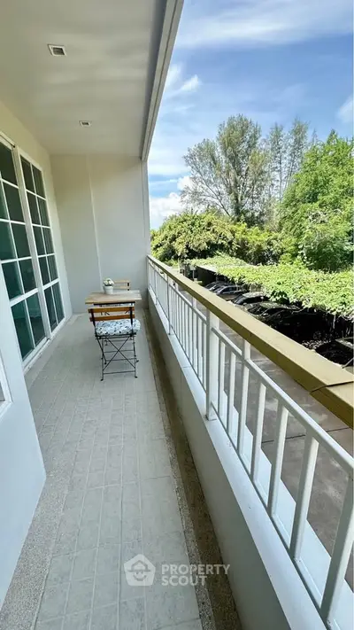 Spacious balcony with scenic greenery view, perfect for relaxation and outdoor dining.