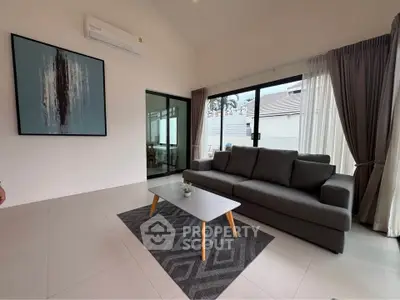 Modern living room with stylish decor and large windows offering natural light.