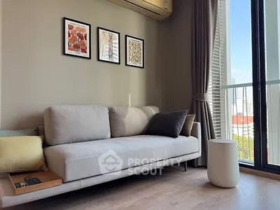 Modern living room with sleek sofa and city view through large windows.