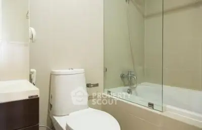 Modern bathroom with sleek design featuring a bathtub and toilet in a compact space.
