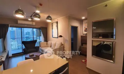 Modern living room with city view, stylish furniture, and open layout in high-rise apartment.