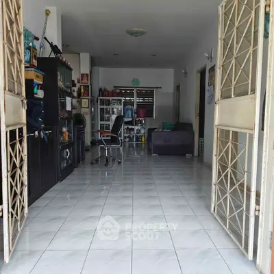 Spacious living room with tiled floor and open layout, featuring modern furniture and ample natural light.