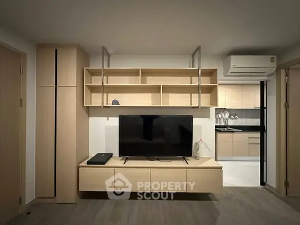 Modern living room with sleek TV unit and open kitchen layout