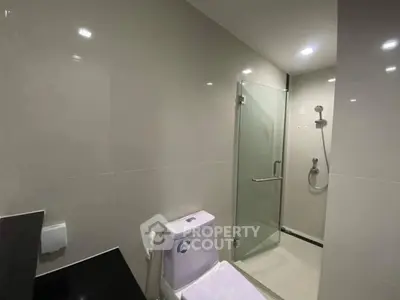Modern bathroom with glass shower and sleek fixtures in a contemporary home.