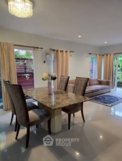 Elegant living room with dining area, featuring stylish furniture and natural light.