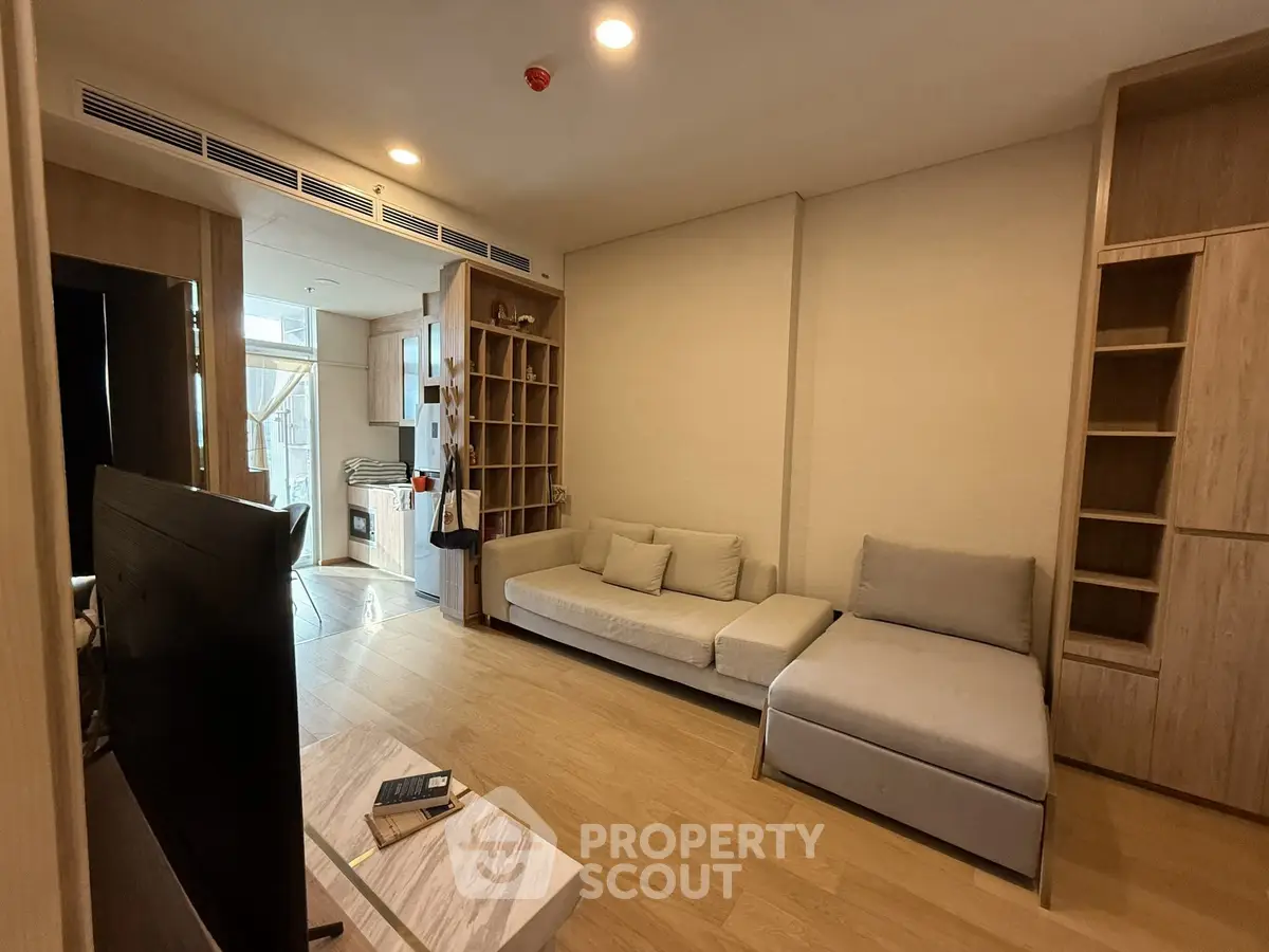 Spacious living room with modern furniture and wooden flooring in a cozy apartment.