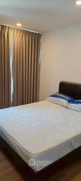 Cozy bedroom with natural light and elegant curtains, perfect for relaxation.