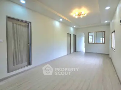 Spacious and bright living room with modern lighting and wooden flooring