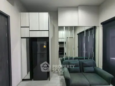 Modern living room with sleek furniture and mirrored wall enhancing space